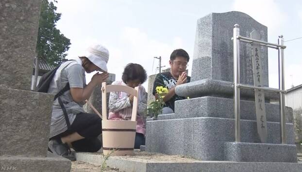 日本冈山县真备町 市民在暴雨灾害后的寺中进行扫墓祭祀