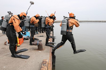 保安厅潜水员潜入浑浊的海水中搜索失踪人员