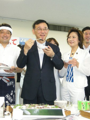 日本自民党谷恒祯一品尝生鱼片 为灾区加油打气
